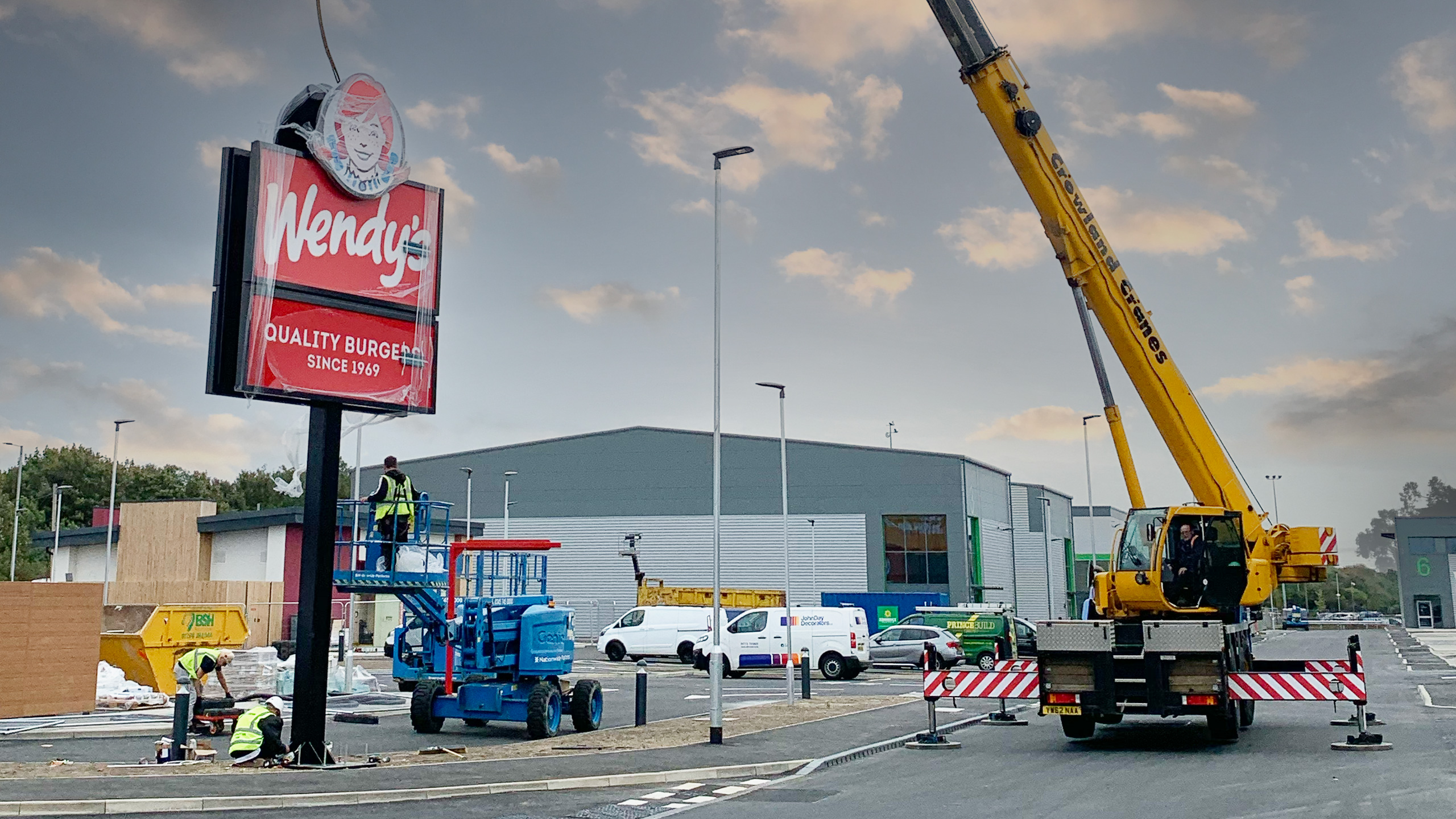 Pylon signs being lowered into position with a crane at Wendy's Peterborough